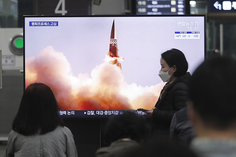 На фото: люди смотрят телевизор с изображением новой управляемой ракеты Северной Кореи во время передачи новостей на железнодорожном вокзале Сусео в Сеуле, Южная Корея