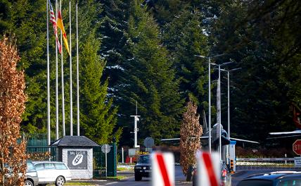 На фото: флаг США поднят на переднем флагштоке у главного входа в аэродром бундесвера, где предположительно хранятся американо-американские ядерные бомбы типа B61, в Бюхеле, Германия