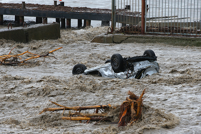 На фото: автомобиль, вынесенный потоком воды на городскую набережную. Река Водопадная вышла из берегов после продолжительных дождей в Ялте.