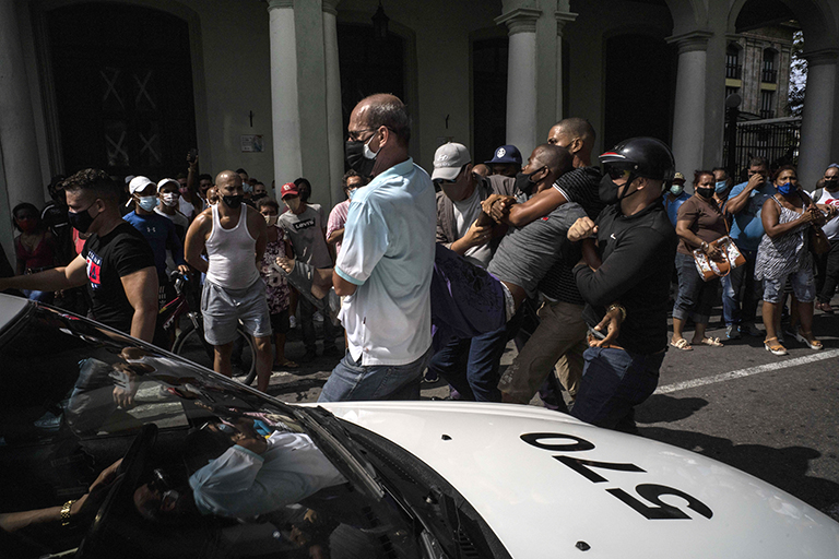 На фото: полиция задерживает антиправительственного демонстранта во время акции протеста в Гаване, Куба.