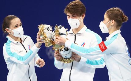 На фото: Камила Валиева, Марк Кондратюк и Анастасия Мишина (ОКР) (слева направо) - золотые медали, на цветочной церемонии.