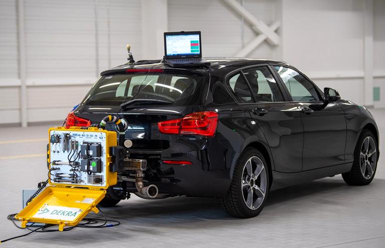 На фото: автомобиль подключен к мобильной системе измерения выбросов в лаборатории выхлопных газов на территории Технологического центра Dekra, Германия