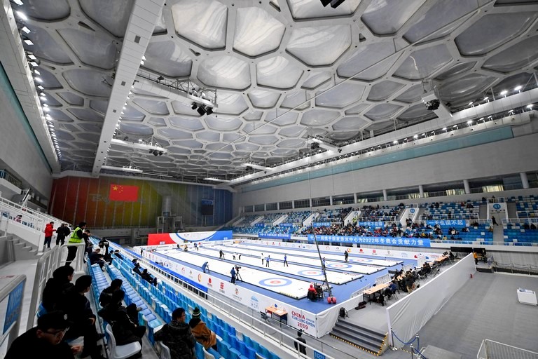 На фото: игра в керлинг в Национальном центре водных видов спорта (Водный куб) в Пекине