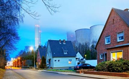 На фото: буроугольная электростанция Нидераусем на фоне жилых домов в районе Ауэнхайм, Германия