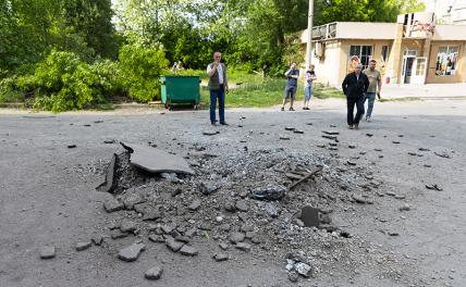 На фото: место падения снаряда на одной из улиц Донецка.
