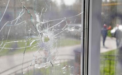 На фото: разбитое в результате обстрела стекло жилого дома