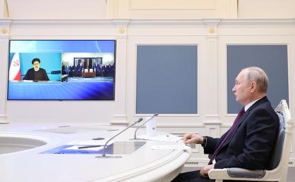 На фото: Президент Владимир Путин в Кремле и президент Ирана Эбрахим Раиси (на экране) во время встречи в режиме видеоконференции, посвященной подписанию российско-иранского соглашения о сотрудничестве по созданию в Иране железной дороги "Решт - Астара"