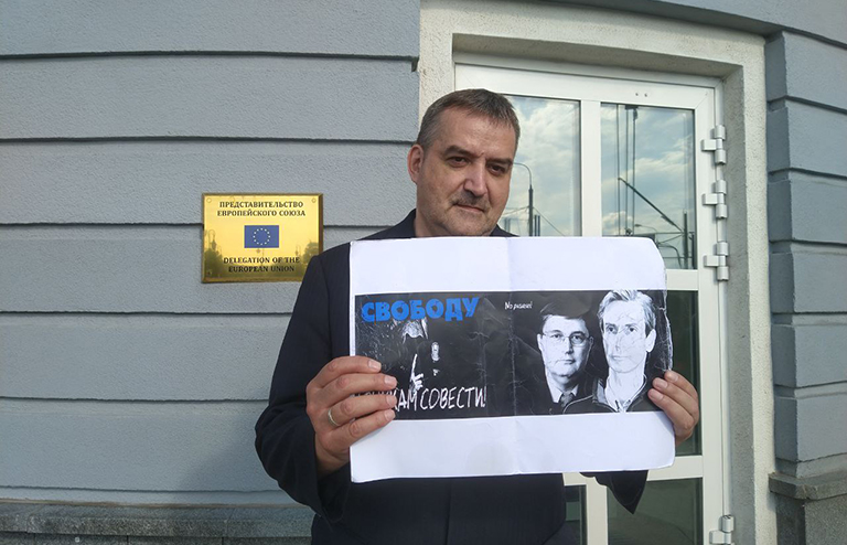 На фото: Гедрюс Грабаускас у стен офиса ЕС с плакатом в защиту полит-узников - А.Палецкиса и С.Середенко, они уже давно в тюрьмах, один в Литве, другой в Эстонии