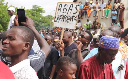 На фото: молодой человек держит табличку с надписью «A bas la France» («Долой Францию»).