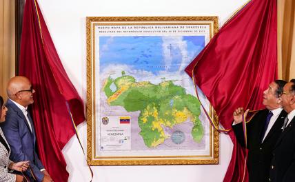 На фото: председатель Национальной ассамблеи Хорхе Родригес (слева) и председатель Специальной комиссии по обороне Гайаны Эссекибо Герман Эскарра представляют новую карту Венесуэлы, которая включает территорию Эссекибо.