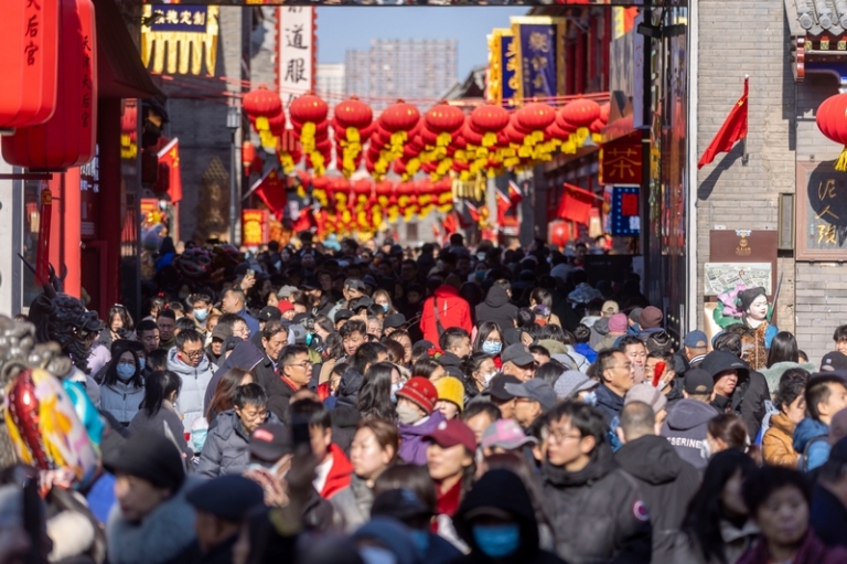 На фото: тристы посещают улицу древней культуры Тяньцзиня, украшенную красными фонарями, в день китайского лунного Нового года.