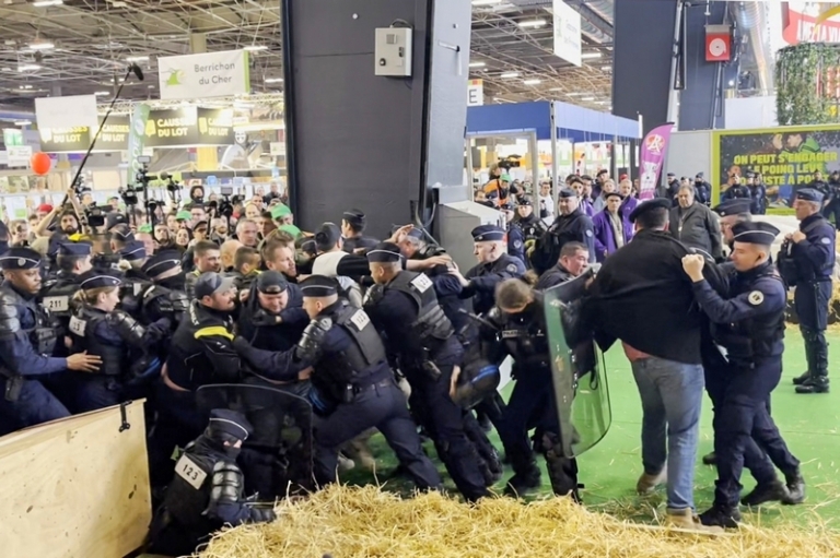 На фото: прорвавшие кордон участники акции протеста и полицейские в павильоне Международного сельскохозяйственного салона в пригороде Парижа, на открытие которого приехал президент Франции Эмманюэль Макрон.