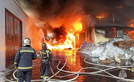 На фото: сотрудники МЧС России во время тушения пожара на складе стройматериалов.