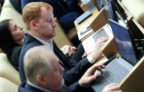 На фото: член комитета Госдумы РФ по бюджету и налогам Денис Парфенов (на втором плане) на пленарном заседании Государственной думы РФ