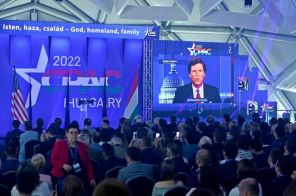 На фото: американский телеведущий и консервативный политический обозреватель Такер Карлсон на экране выступает с речью на конференции CPAC в Будапеште, Венгрия, 2022 год.
