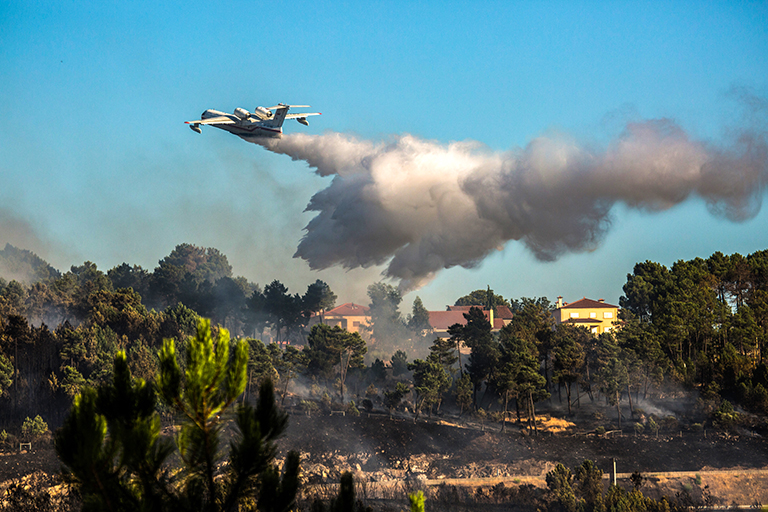 На фото: самолет МЧС РФ Бе-200ЧС во время тушения лесных пожаров в городе Вила-Реал, Португалия, 2016 год