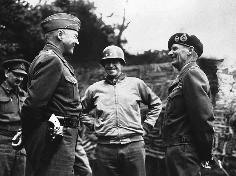 На фото: генерал-лейтенант Джордж Паттон, генерал-лейтенант Омар Брэдли и генерал сэр Бернард Монтгомери обсуждают ход французской кампании где-то во Франции 19 августа 1944 года