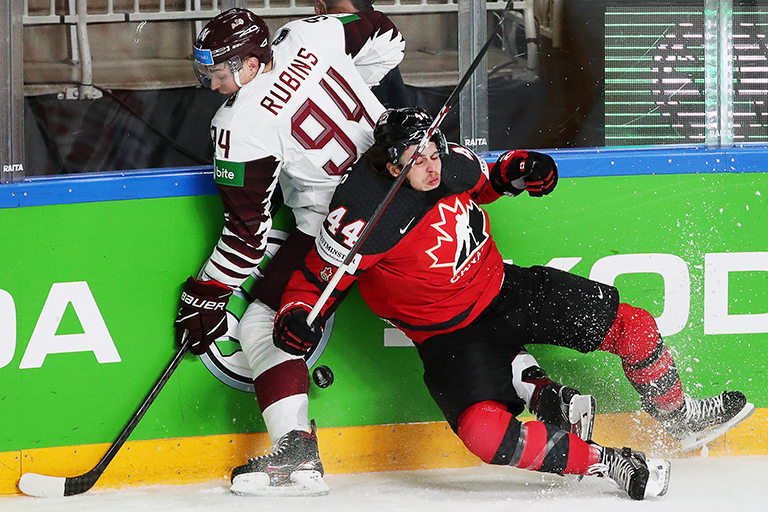 На фото: Кристиан Рубинс (Латвия) и Макс Комтуа (Канада) (слева направо) в матче группового этапа чемпионата мира по хоккею - 2021: Канада - Латвия