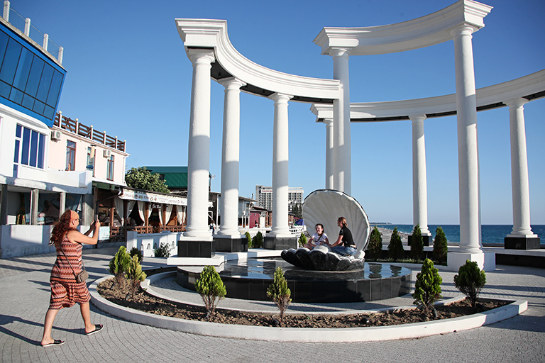 На фото: туристы фотографируются на городской набережной в Гаграх, Абхазия