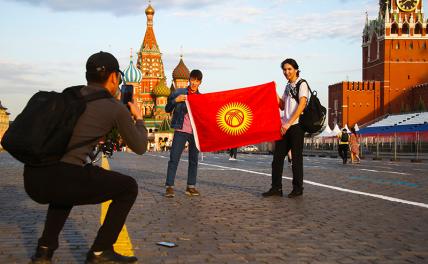 На фото: отдыхающие фотографируются с флагом Киргизии на Красной площади в Москве