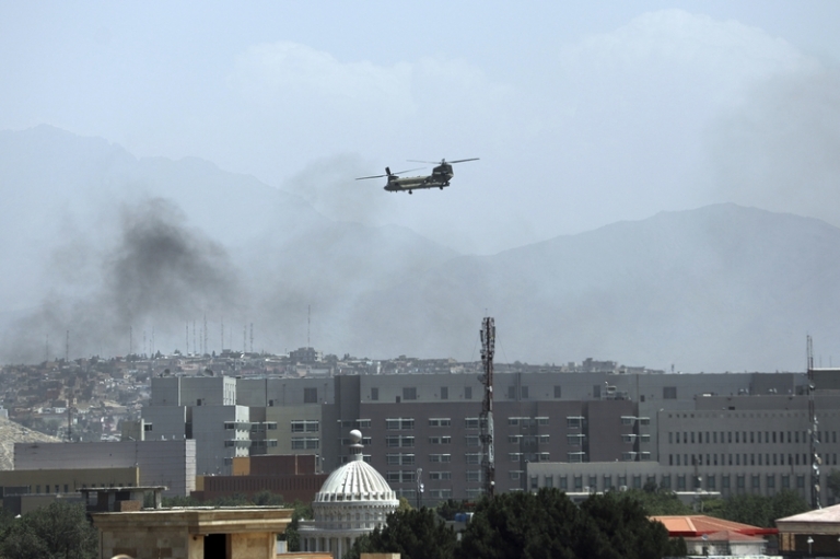 На фото: американский военный вертолет "Чинук" летает над Кабулом, который начали окружать сторонники радикального движения "Талибан" * (запрещено в РФ)