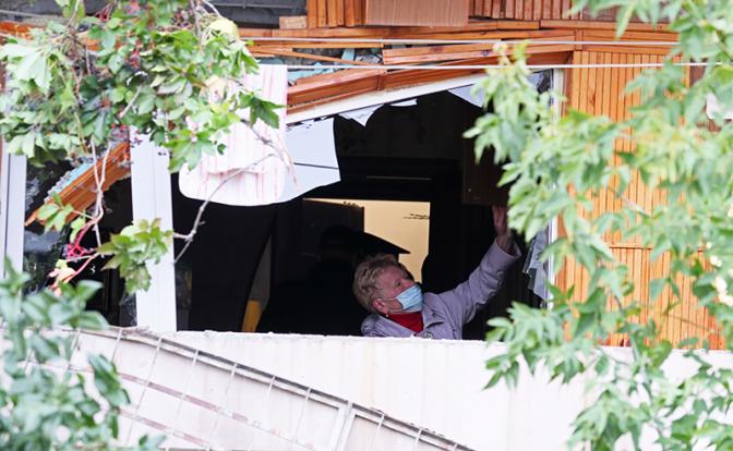 На фото: женщина на поврежденном балконе жилого девятиэтажного дома на улице Индустрии 57/2, где произошел взрыв бытового газа.