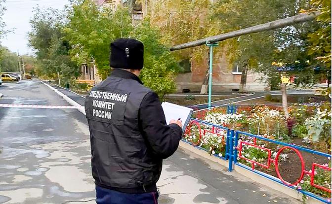 На фото: сотрудник следственного комитета РФ у дома, где были обнаружены убитые женщины.