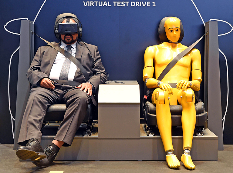 На фото: посетитель сидит в симуляторе безопасности вождения у киоска Toyota во время Женевского международного автосалона в Женеве, Швейцария