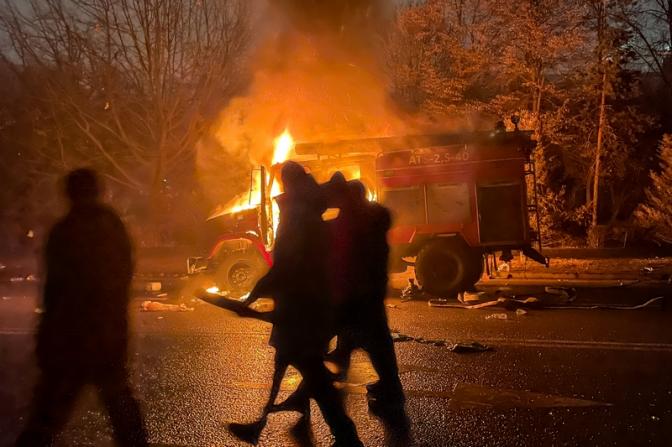 На фото: горящий автомобиль возле здания мэрии (акимат) в Алма-Ате. Участники протеста против роста цен на топливо ворвались в здание акимата и пожодгли его.
