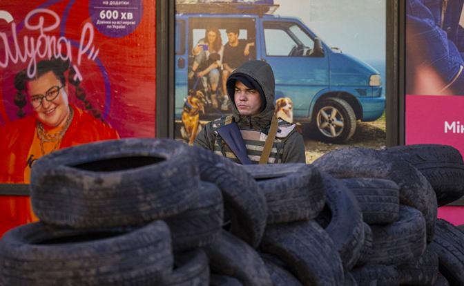На фото: доброволец территориальной обороны Украины на блокпосту на одной из улиц города.