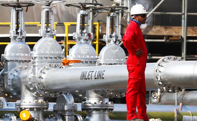 На фото: рабочий на территории нефтеперерабатывающего завода компании Saudi Aramco на месторождении Абкаик.