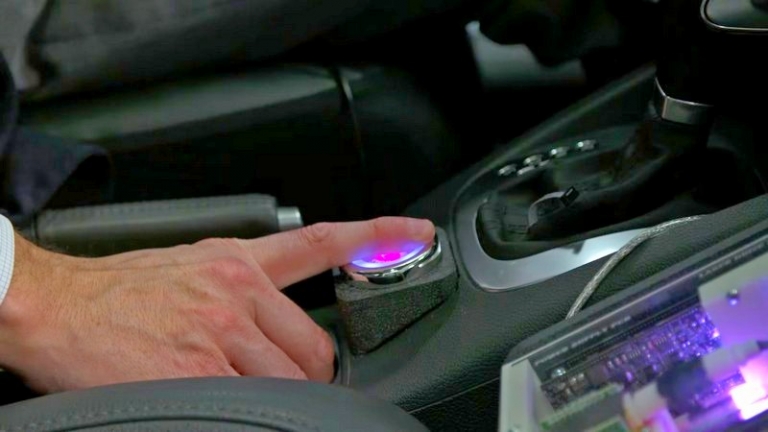На фото: эта технология измеряет уровень алкоголя в крови под поверхностью кожи, пропуская инфракрасный свет через кончик пальца водителя. Она будет интегрирована в текущие элементы управления автомобилем, такие как кнопка запуска или рулевое колесо, и будет считывать множество точных показаний