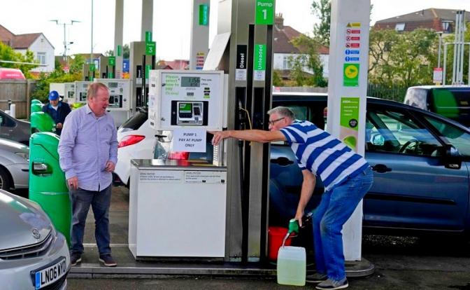 На фото: мужчина наполняет канистру на заправочной станции в Лондоне