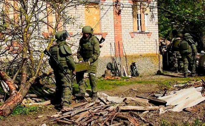 На фото: российские саперы во время очистки местности от взрывоопасных предметов в районе поселка Каменка Изюмского района, Харьковская область