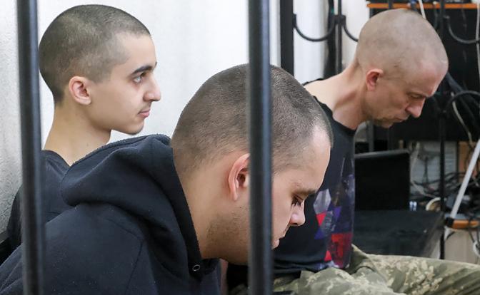 На фото: гражданин Марокко Саадун Брагим, граждане Великобритании Эйден Эслин и Шон Пиннер (слева направо), обвиняемые в участии в боевых действиях в составе украинских вооруженных формирований в качестве наемников