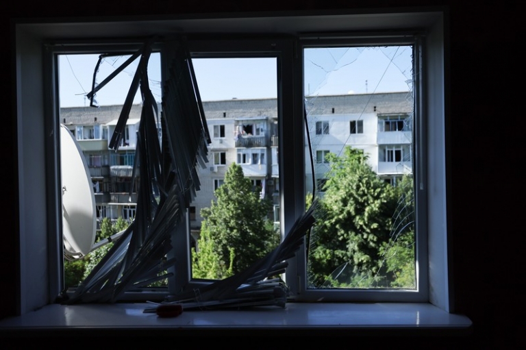 На фото: разбитое окно в здании, разрушенном в результате обстрела ВСУ