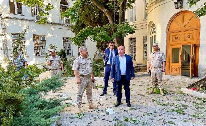 На фото: губернатор Севастополя Михаил Развожаев (в центре) у штаба Черноморского флота РФ, который был атакован украинской стороной, предположительно, с использованием беспилотника.