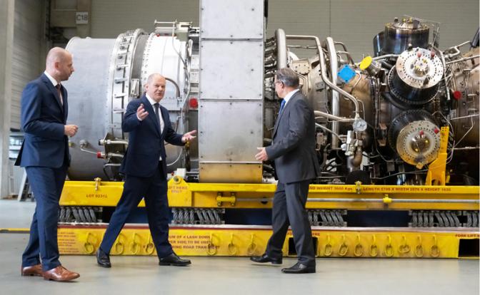 На фото: канцлер Германии Олаф Шольц (второй слева) и генеральный директор Siemens Energy Кристиан Брух (слева) во время посещения производственной площадки Siemens Energy, где находится турбина для газопровода "Северный поток".