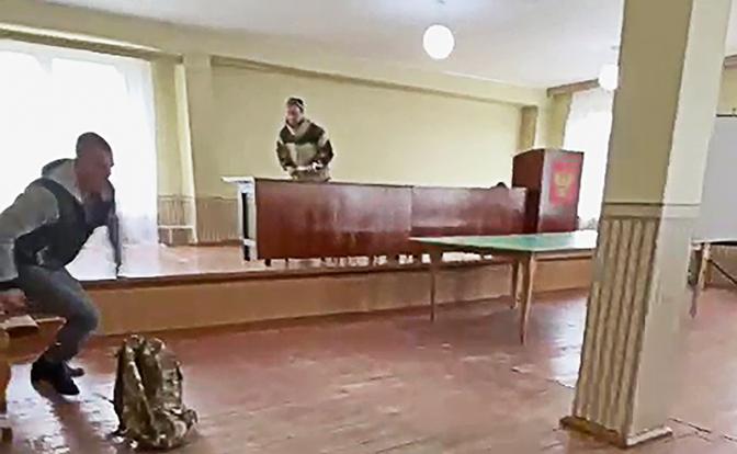 На фото: 25-летний мужчина (в центре), устроивший стрельбу, в военкомате Усть-Илимска.