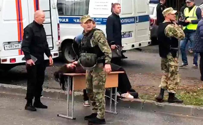 На фото: сотрудники полиции и раненый около школы №88, где в результате стрельбы погибли не менее 6 человек и 20 получили ранения.