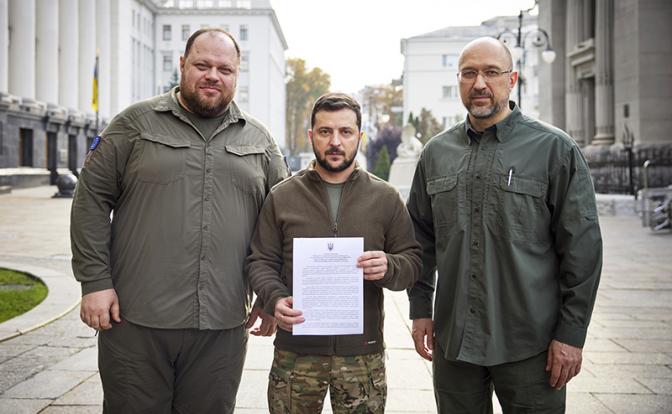 На фото: председатель Верховной Рады Украины Руслан Стефанчук, президент Украины Владимир Зеленский, премьер-министр Украины Денис Шмыгаль (слева направо) после подписания заявки на вступление Украины в НАТО в Киеве