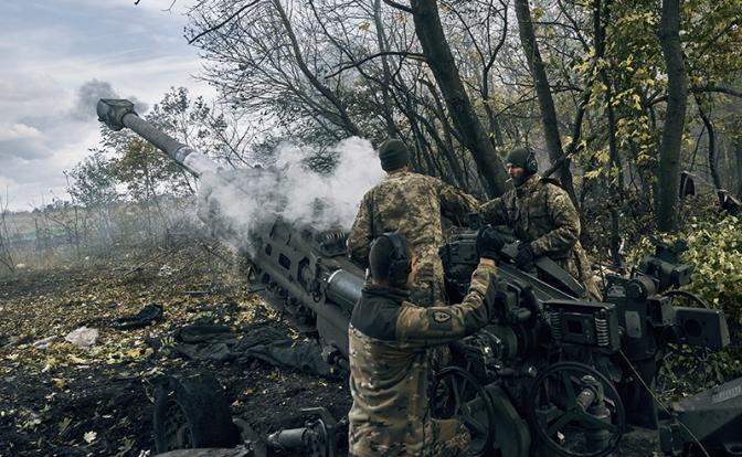 На фото: украинские солдаты стреляют из поставленной США гаубицы M777