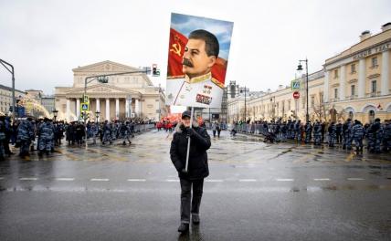 На фото: мужчина с портретом Иосифа Сталина