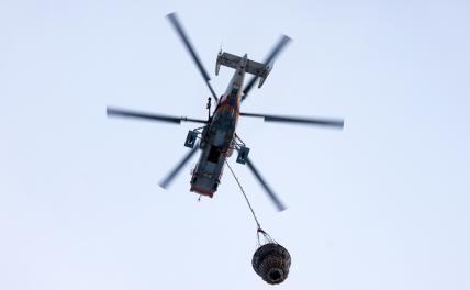 На фото: пожарный вертолет во время тушения пожара в складском помещении на улице Добролюбова.