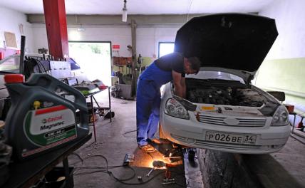 На фото: ремонт автомобиля в гаражном автосервисе