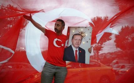 На фото: мужчина держит фотографию президента Турции Реджепа Тайипа Эрдогана