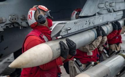 На фото: моряки ВМС США загружают боеприпасы «Сайдуиндер» на F / A-18E Super Hornet