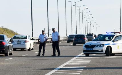 На фото: сотрудники ДПС у очереди из автомобилей в сторону Крымского моста.