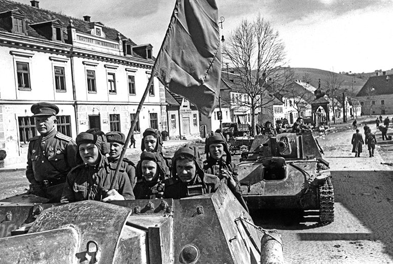 На фото: самоходные артиллерийские установки СУ-76М 1513-го самоходно-артиллерийского полка под командованием гвардии подполковника Василия Степановича Шоничева (слева) на улице одного из населенных пунктов Австрии, освобожденного от немецко-фашистских захватчиков, апрель 1945 года