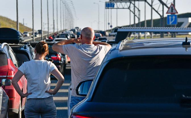 На фото: люди у автомобилей, которые стоят в очереди в сторону Крымского моста, Краснодарский край.